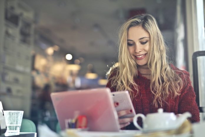 woman-in-red-sweater-holding-white-cellphone-3785419